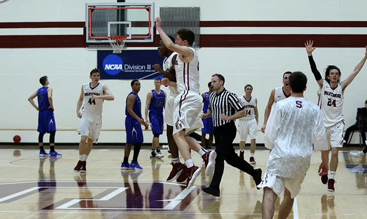 Men's basketball team celebrates win.