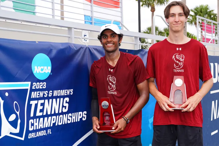 Utham Koduri and Michael Melnikov hold trophies on tennis court