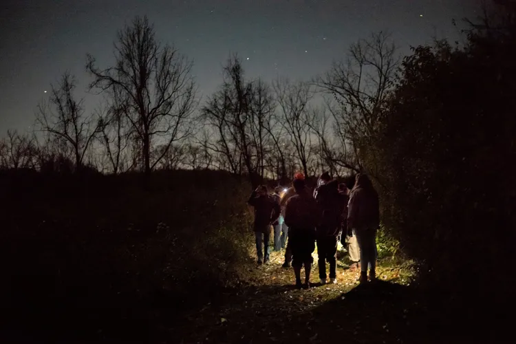 Students stand outside at night