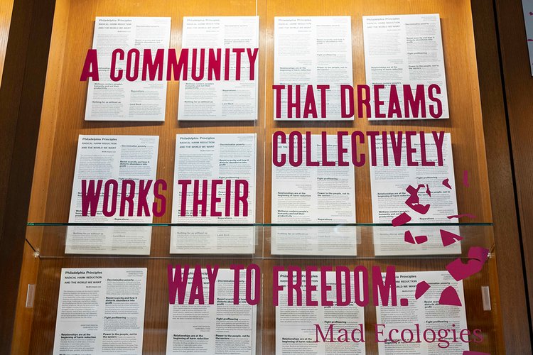 Library exhibit that has words "A COMMUNITY THAT DREAMS COLLECTIVELY WORKS THEIR WAY TO FREEDOM"