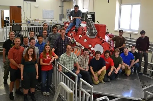 Team posing in front of equipment as part of Madison Plasma Dynamo Experiment (MPDX)