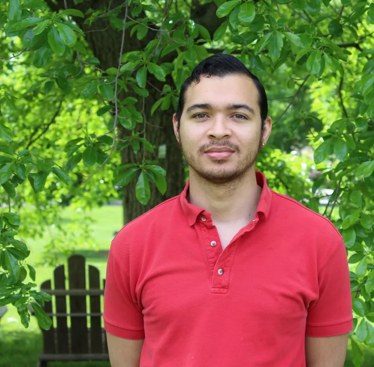 photo of student standing in front of tree