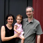 Assistant Professor of Philosophy Alan Baker standing with his wife and child