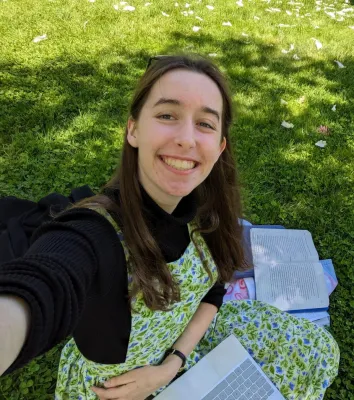 Elsa Toland seated on a lawn with books and study materials nearby