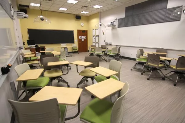 Green tablet arm chairs in Kohlberg room 116