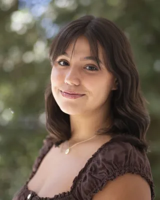 Mikaela smiles at the camera.
