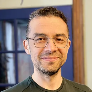 Roberto Vargas wearing glasses, a green tee shirt and a smile