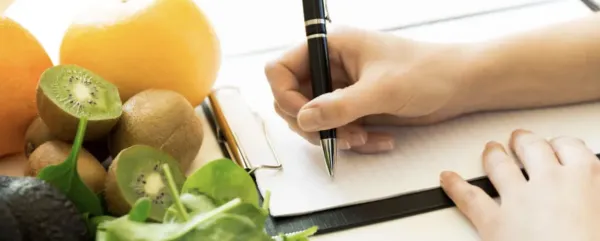 notebook paper, pencil and fruit and food on a table