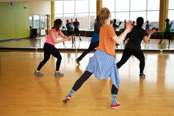 people dancing in an exercise studio with mirrors