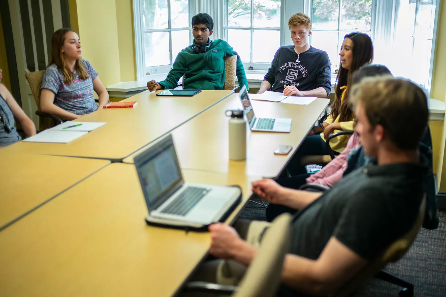 Students sit in desks in a small circle