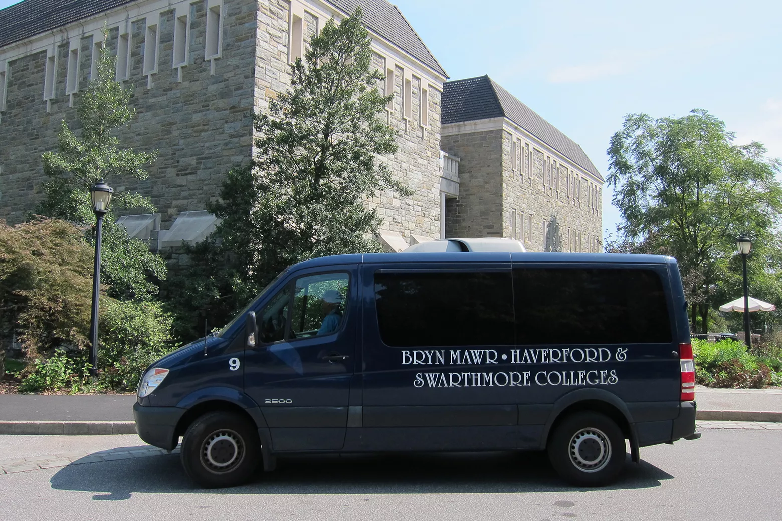 Blue shuttle bus in front of library