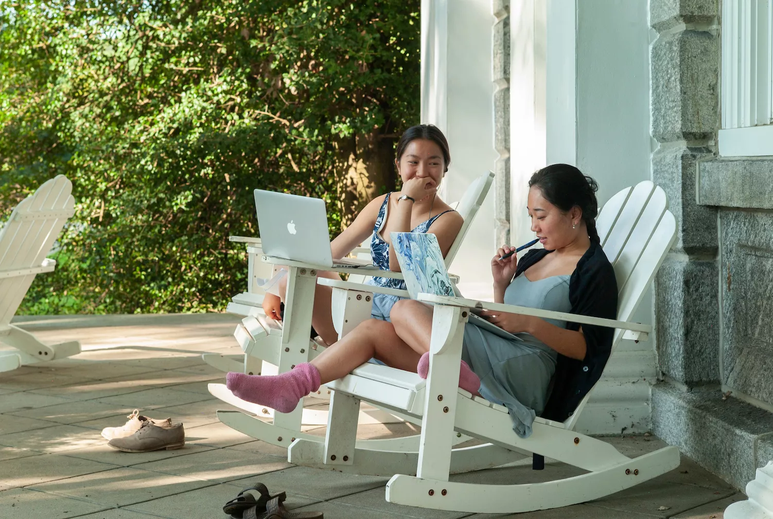 Swarthmore students sit in white chairs on the porch of Parrish Hall