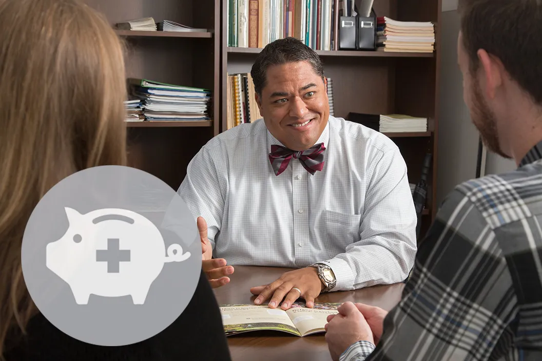 Person sits at desk in financial aid office. Gray circle featuring symbol of piggy bank in bottom left corner.