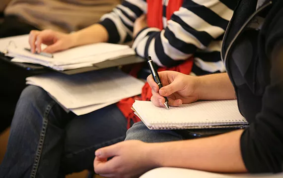 Books, papers, pens, and students during class.