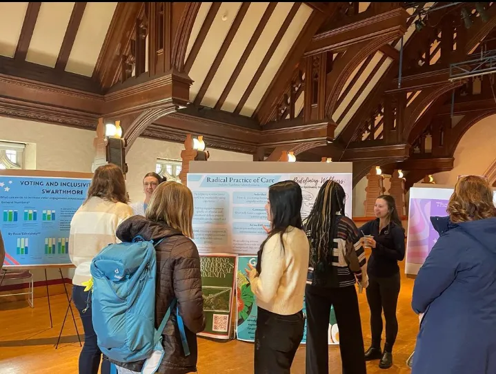 A group of people presenting posters to others