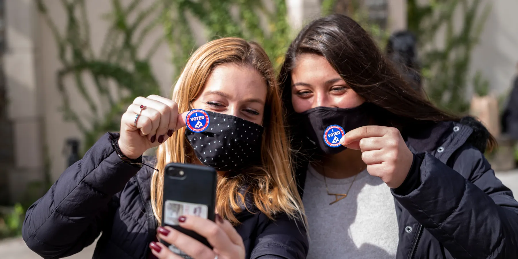 Students taking photo with their "I voted" sticker.