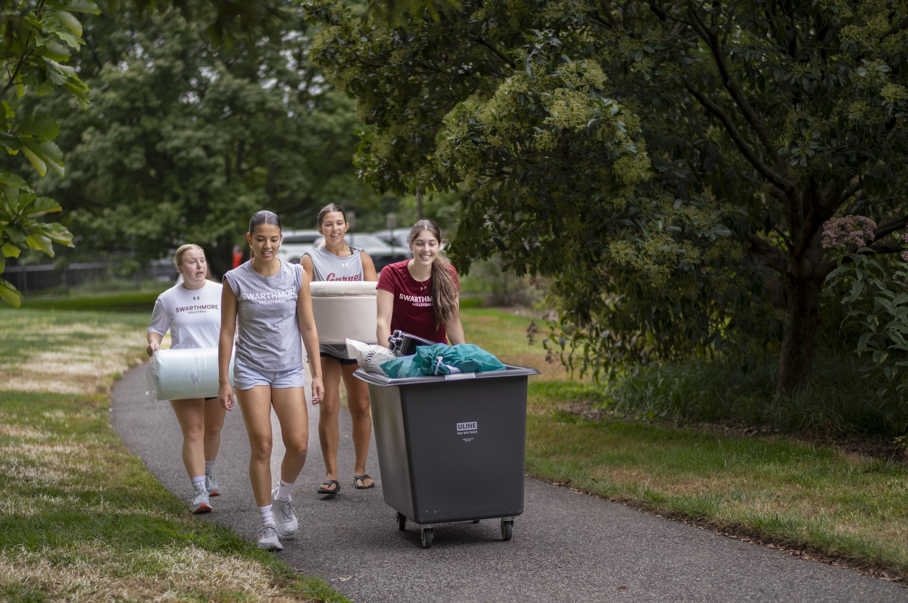 A group of four students push a move-in cart.