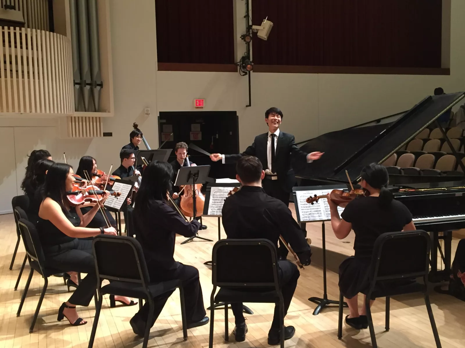 student conducting the college orchestra on stage