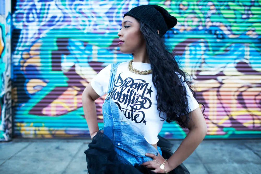 Singer songwriter Aisha Fukushima standing in front of outdoor mural