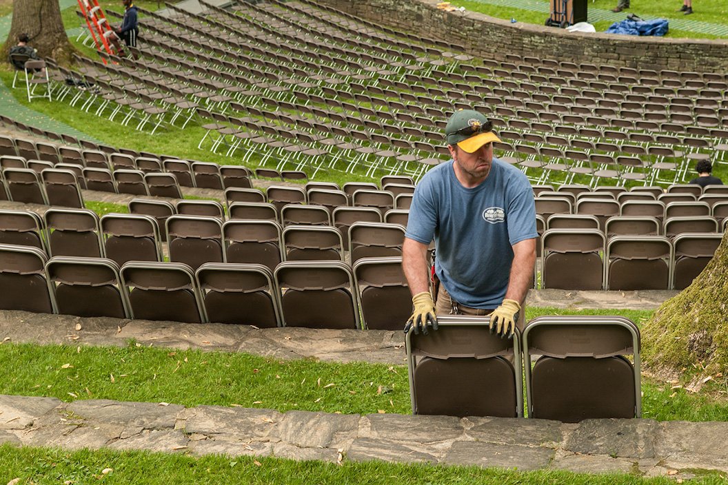 Member of the grounds department sets up chairs in Scott Amphitheater