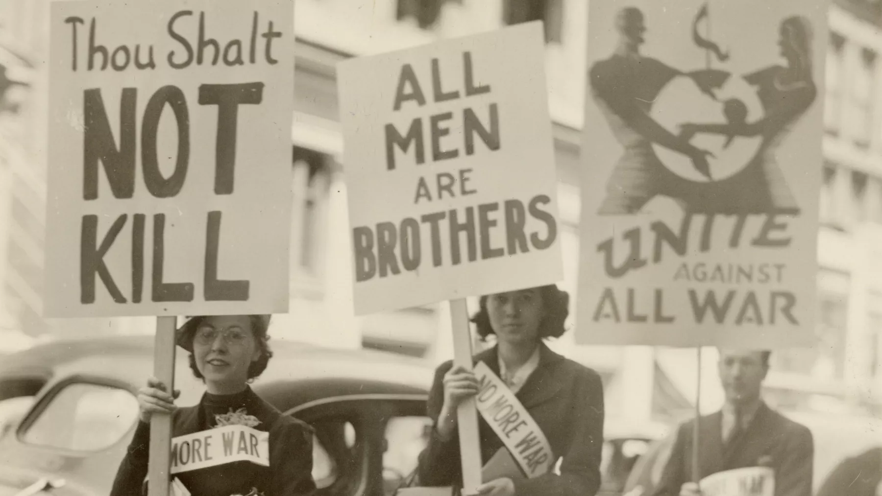 three protesters carrying anti war posters