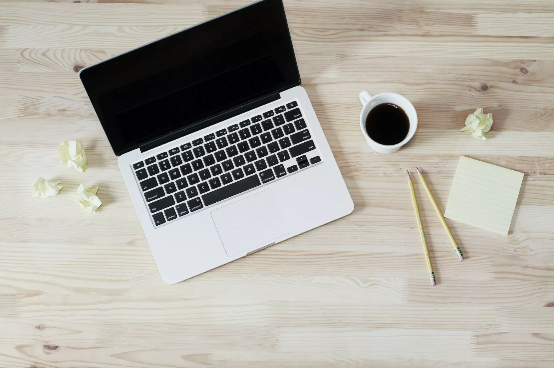 picture of a laptop with a cup of coffee next to it