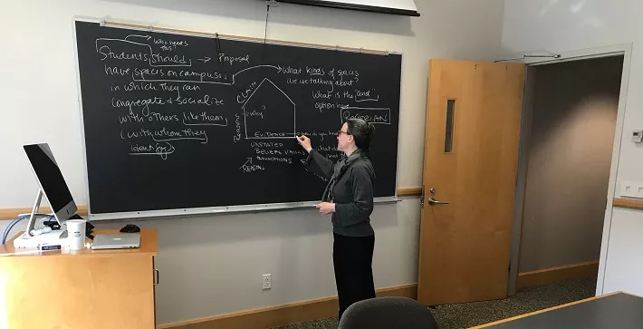 Professor Alba Newmann Holmes teaching at a blackboard.