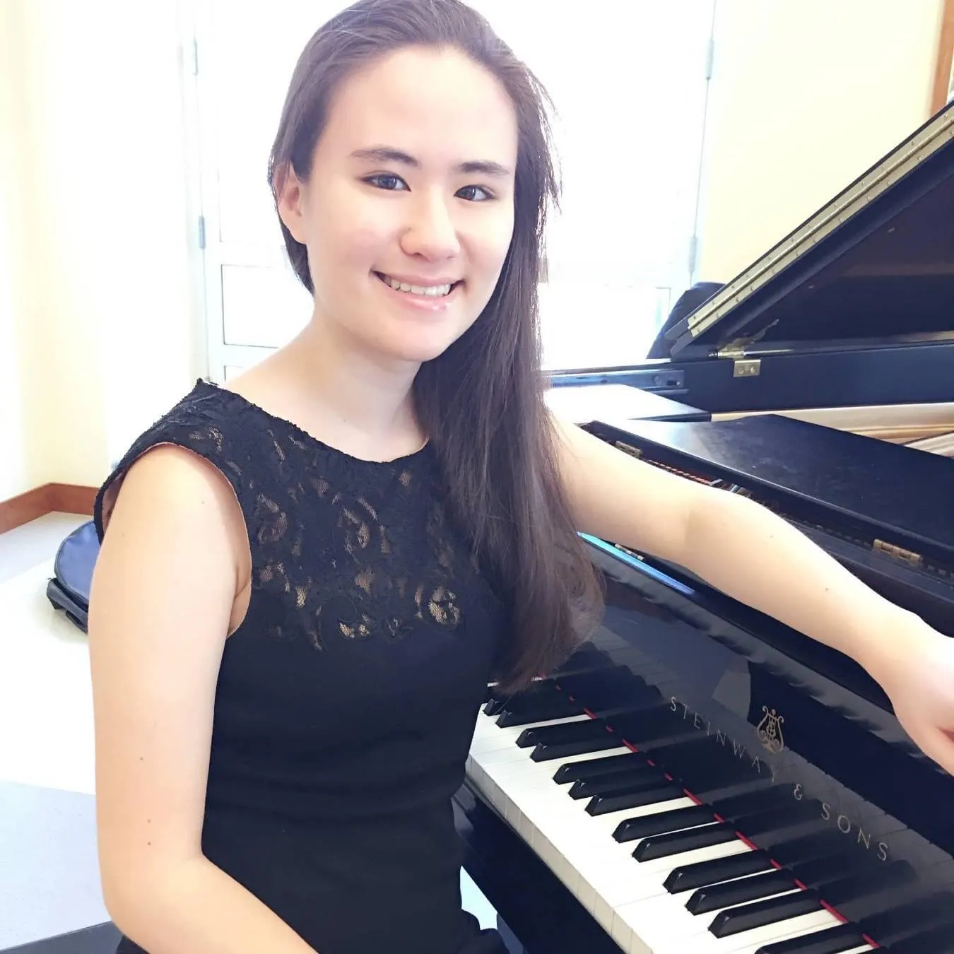 Mia Shoquist '21 sits at a piano