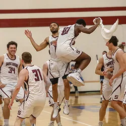 Members of men's basketball team celebrate after winning game