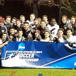 Swarthmore men's soccer team poses with NCAA banner