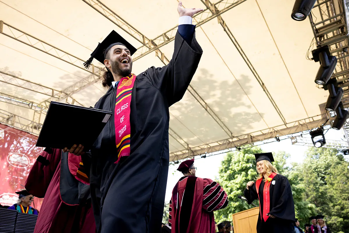 Student celebrates after receiving diploma on stage