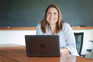 Maria Olivero at desk with laptop